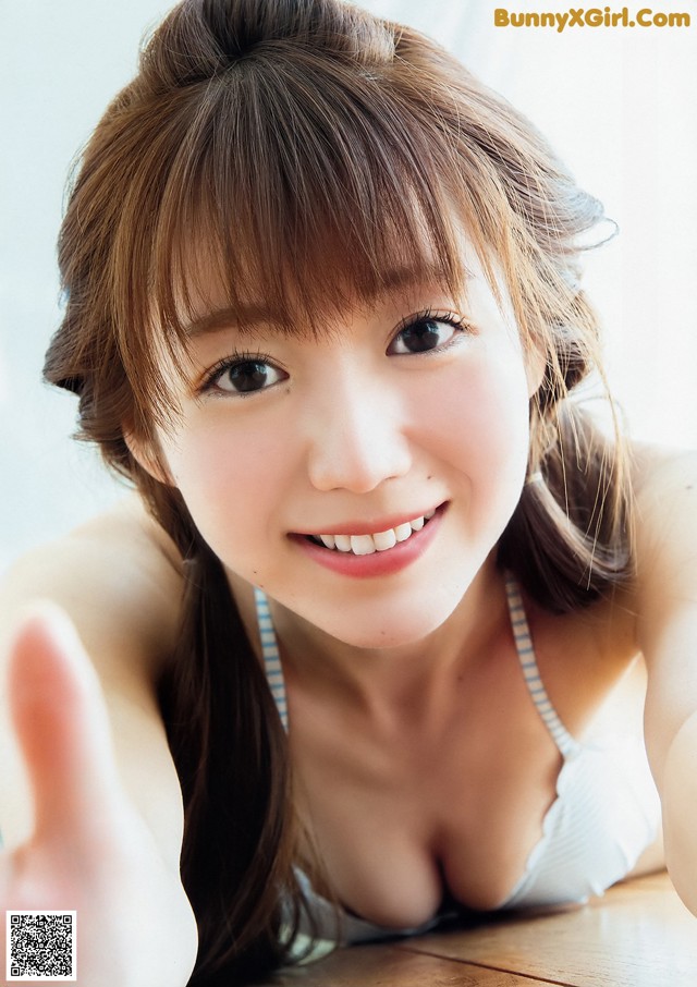 A young woman laying on top of a wooden table.