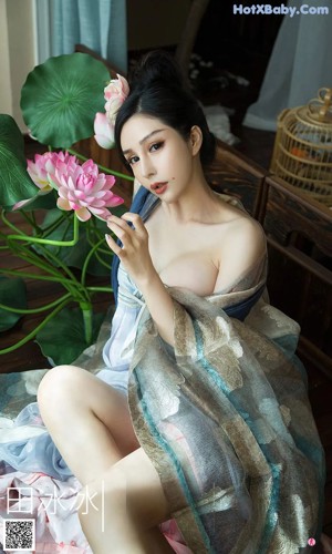 A woman in a pink and blue dress posing for a picture.
