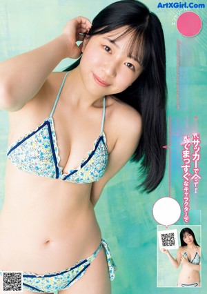 A woman in a bikini sitting on a pink background.
