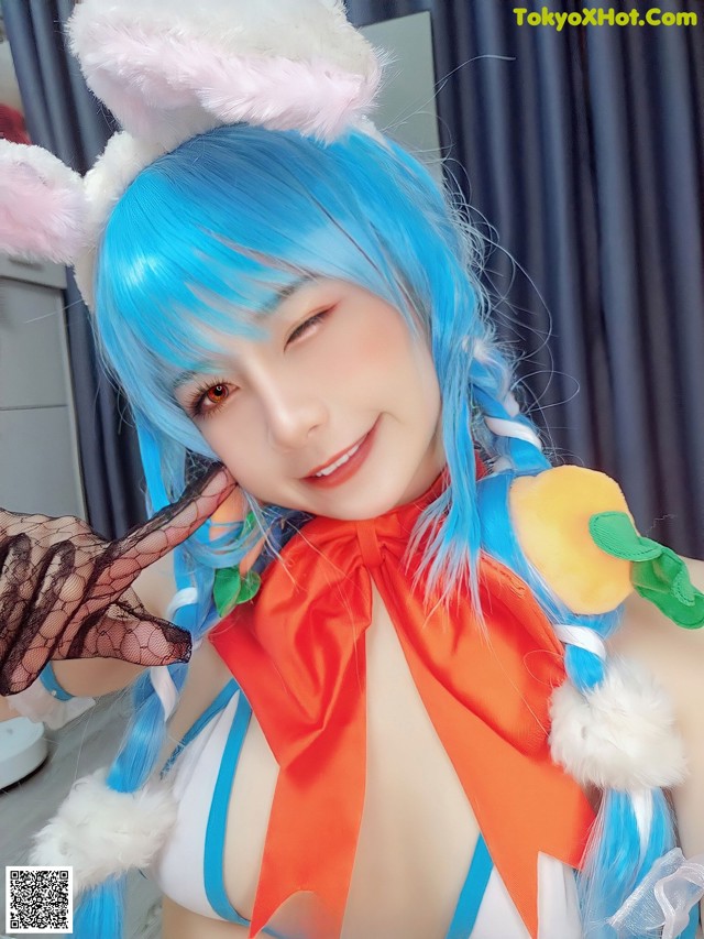 A woman with blue hair wearing a bunny costume.