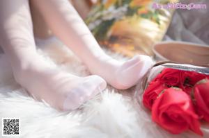 A woman in a white dress holding a bouquet of roses.