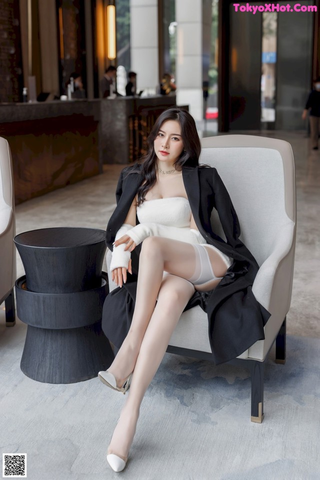 A woman sitting on a chair in a hotel lobby.