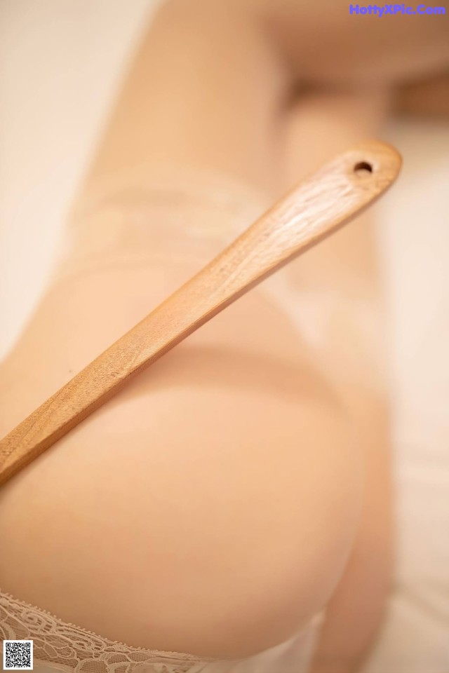 A close up of a woman's butt with a wooden spoon on it.