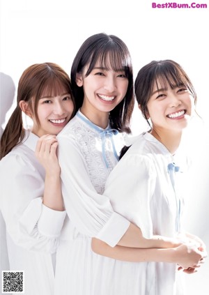 A group of young women laying on top of a bed.