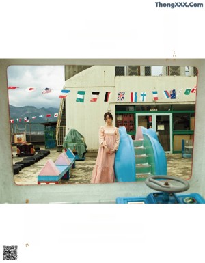 A woman standing in front of a window with curtains.