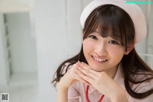 A woman in a pink nurse outfit sitting on a bench.