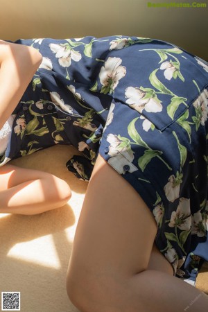 A woman laying on top of a bed next to a window.