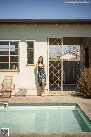 A woman in a white bikini laying on a window sill.