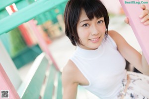 A woman in a white top and pink panties posing for a picture.