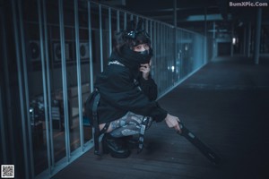 A woman in a black outfit is sitting on some stairs.