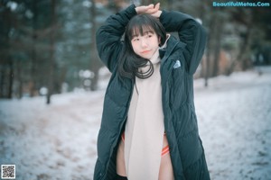 A woman sitting on some steps in the snow.