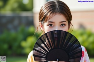 A woman in a kimono holding a fan in her hand.