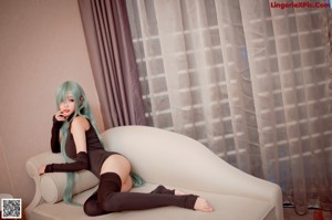 A woman sitting on a couch with her legs crossed.