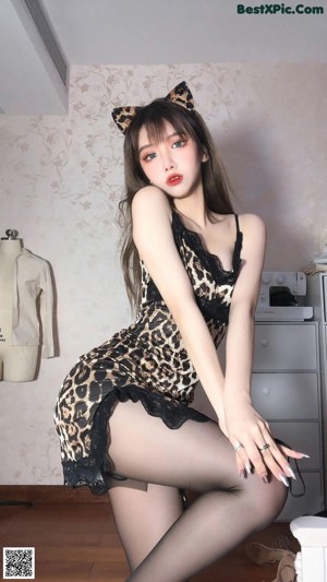 A woman in a leopard print dress posing for a picture.