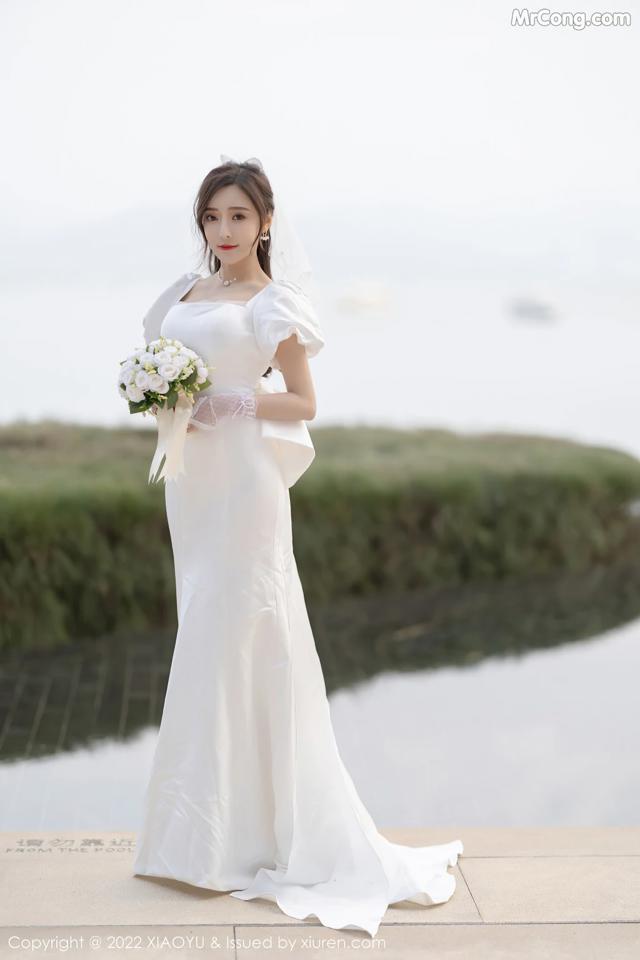 A woman in a wedding dress holding a bouquet of flowers.