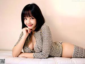 A woman in a yellow top and blue shorts posing for a picture.