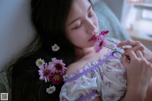 A woman in a white dress holding a bouquet of flowers.