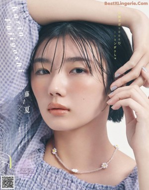 A woman with long brown hair wearing a white shirt and gold earrings.