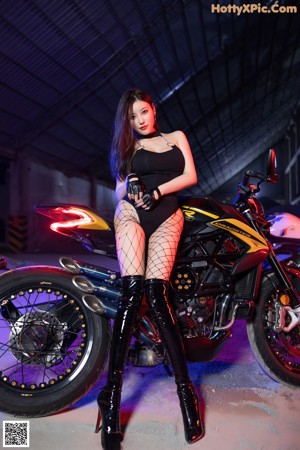 A woman sitting on top of a motorcycle in the snow.