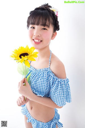 A little girl in a blue and white checkered bikini.