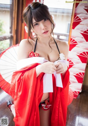 A woman in a red kimono posing for a picture.