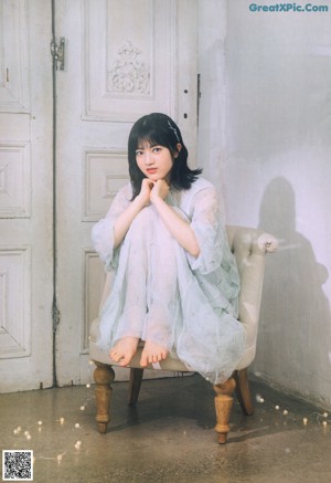 A young woman leaning on a window sill.