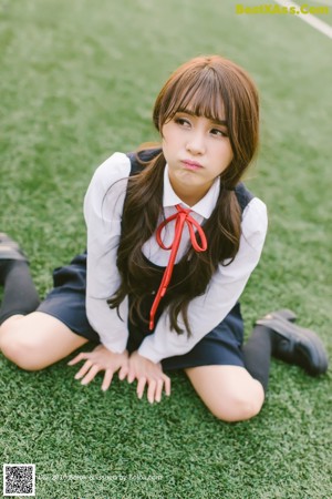 A young woman in a school uniform posing for a picture.