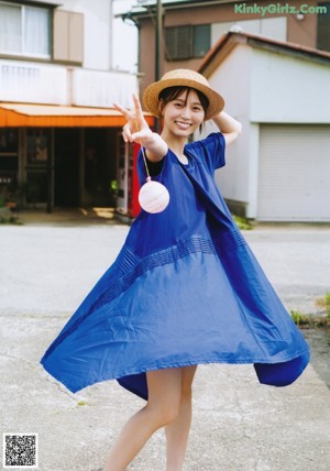 A woman in a blue and white striped dress on the beach.